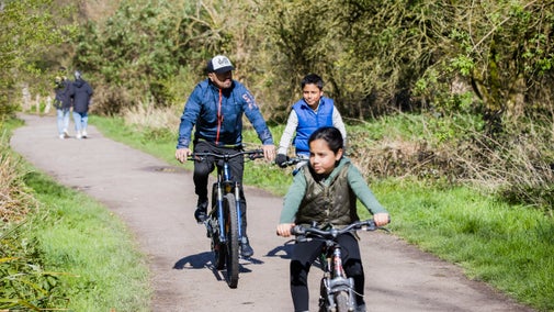 A family on a bike ride at Morden Hall Park, London